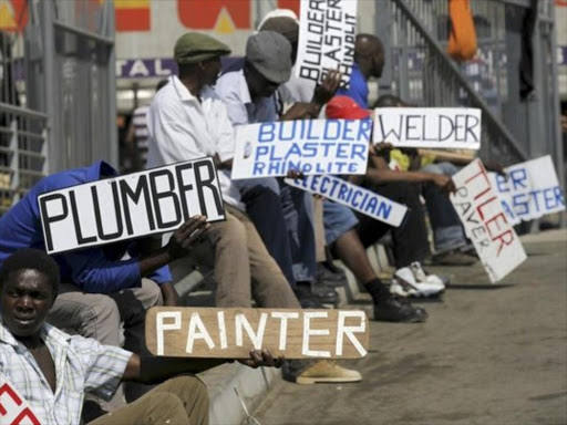 Unemployed youth hold placards advertising their skills