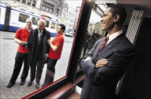 UNREAL: A wax figure of Barack Obama is on display at Madame Tussauds Wax Museum, as workers carry a wax figure of George W Bush outside the building in Amsterdam, the Netherlands. Obama's figure was also unveiled at Madame Tussauds in London, Berlin, New York and Las Vegas. 19/01/2009.Evert Elzinga. © AP.