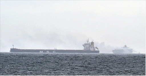 Smoke can be seen billowing from the ship