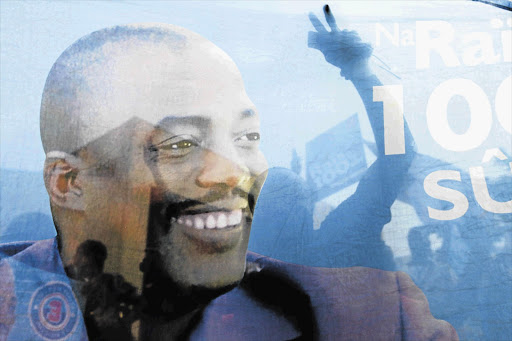 Supporters of Democratic Republic of the Congo President Joseph Kabila celebrate in the background of his image after his controversial re-election.