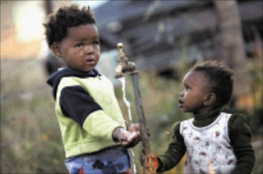 Lulama Hlanjwa township infants Yonela Jamela, and Pamela Fuma play with what could be Barkly east's death trap - water that has killed at least 80 children in the Ukhahlamba municipal district area, including their own siblings. Picture: NIGEL LOUW. 17/04/2008. ©Daily Dispatch.