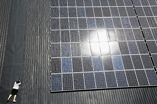 TRICKY EXPOSURE: Elliott White photographs the roof-mounted solar-panel array at the Black River Office Park, in Observatory, Cape Town.