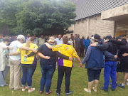 A pastor leads community members in prayer