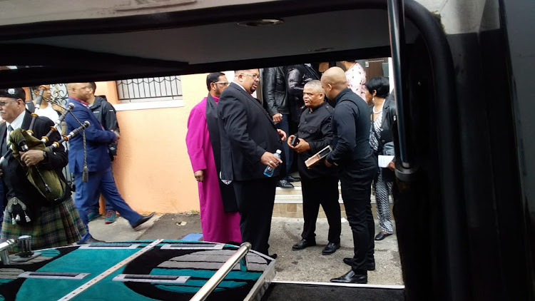 Pastor Ivan Waldeck, centre, outside Rashied Staggie's house in Salt River while his coffin was inside on December 21 2019.