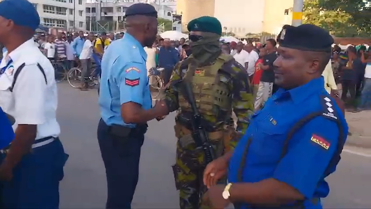 A police officer and a KDF soldier shake hands after burying the hatchet following an ugly face-off over the weekend at the Likoni crossing channel in Mombasa, April 29, 2024.