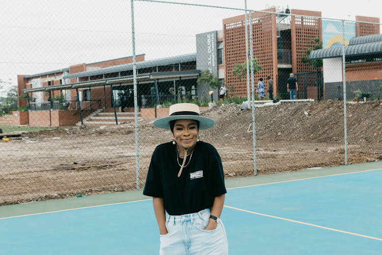 Nomzamo Mbatha poses on the sports grounds.