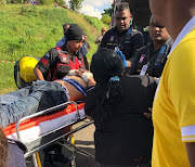 Emergency personnel tend to a teen after a steel barrier sliced through his car. 