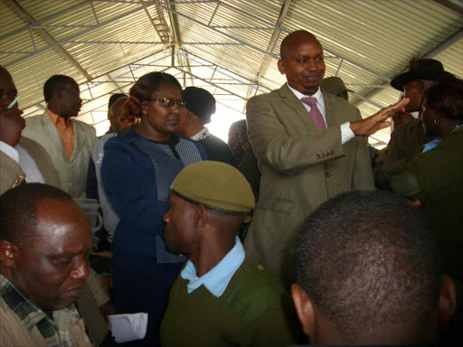 1-2.A Nyandarua government official,Mbugua Muchoki try to calm irate traders during an elections at Ol,kalou open air market on Thursday.The election was called off to avert violence.