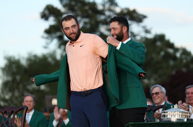 Scottie Scheffler of the US is presented with the green jacket by Spain's Jon Rahm after winning The Masters at Augusta National Golf Club in Augusta, Georgia on Sunday.