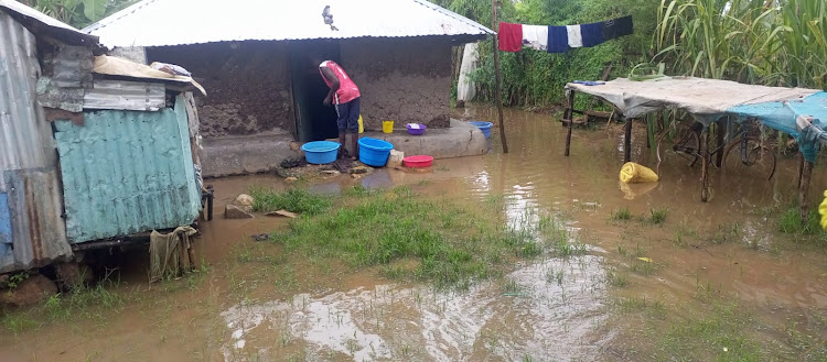A man near his house that is marooned by floods in Karachuonyo constituency in Homa Bay county