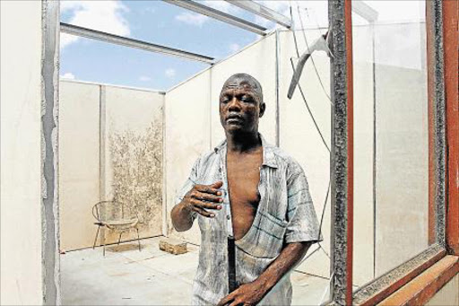 DISAPPOINTED: Blind Buyile Kwezi, 44, of Mdantsane, who is blind, stands next to the has expressed disappointment at the donation of an appalling dilapidated temporary shelter that was given to him by BCM last month. The old shelter has no roof and broken flooring, walls and windows