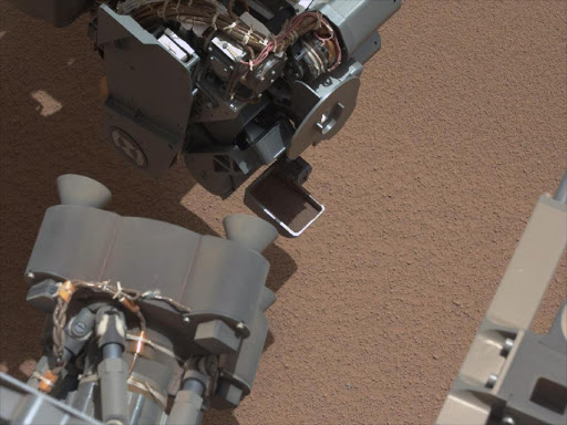 This image from the right Mast Camera (Mastcam) of NASA's Mars rover Curiosity shows a scoop full of sand and dust lifted by the rover's first use of the scoop on its robotic arm. In the foreground, near the bottom of the image, a bright object is visible on the ground. The object might be a piece of rover hardware.