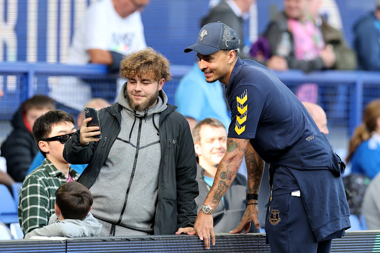 Dele Alli poses for a photo with an Everton fan prior to a Premier League match
