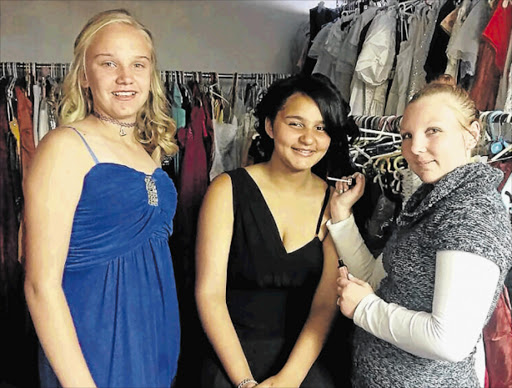 DOLLED UP: Angelique Abrahams of Project Rags to Riches (far right) applies the finishing touches to Shakira Lee Binneman's makeup while Jenene Cloete looks on, ahead of the girls' Grade 7 farewell dance Picture: BARBARA HOLLANDS