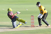 Tony de Zorzi of the Tshwane Spartans hits the ball as Dane Vilas watches on from behind the stumps during the Mzansi Super League match at SuperSport Park in Centurion outside Pretoria on November 28, 2018.
