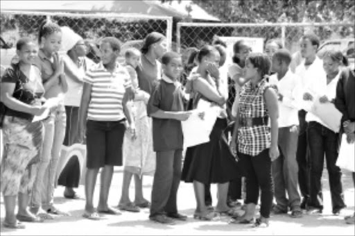 NO WAY: Parents and their children outside the school gates after being refused entry. PHOTO: ELIJAR MUSHIANA. 14/01/2010. © Sowetan. 14 JANUARY 2010 THURSDAY: NO ADMISSION: Parents and some of more than hundred unhappy pupils from Millenium Combined school near Polokwane in Limpopo locked out for registration because of overcrowded. PHOTO: ELIJAR MUSHIANA