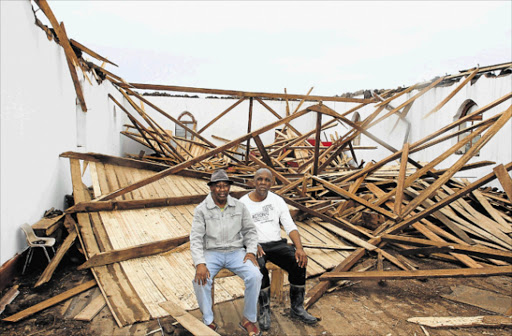 IN RUINS: The Methodist Church of Southern Africa’s Ncambedlana head Reverend Thobile Ntlabathi and Vuyani Ndiko in the ruins of the church hall, after a tornado swept through the area Picture: LULAMILE FENI