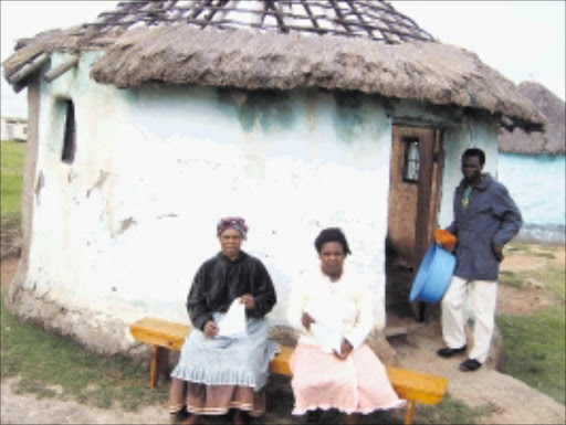 MOURNING: Siphosethu Mtikita's grandmother Nophumzile, her mother Nomfundo Madyibhi and her uncle Koko Mtikita outside one of the three rondavels the family shares.Pic: Botwekazi Ndungane. 02/02/2010. © Sowetan.