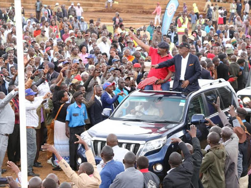 Kanu Secretary General Nick Salat with Baringo senator Gideon Moi wave at hundreds of residents atop their vehicle as they arrive at the Bomet stadium on Sunday./FELIX KIPKEMOI