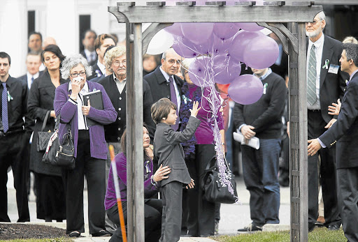 POIGNANT MOMENT: Jake Hockley, 8, releases balloons for his brother Dylan, 6, one of 20 children killed at Sandy Hook Elementary School last week. A service was held for Dylan and other victims on Friday in Bethel, Connecticut