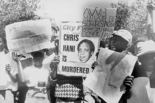 April 1993: Protestors march through the streets after Chris Hani's assassination on 14 April 1993. Secretary-General of the South African Communist Party Martin Chris Hani was assassinated on 14 April 1993. Approximately 1.5 million people participated in the protests and marches that followed his assassination. In October 1993, Clive Derby-Lewis of the Conservative Party and a Polish immigrant, Janusz Walus, were found guilty for Hani's murder, and were sentenced to death.