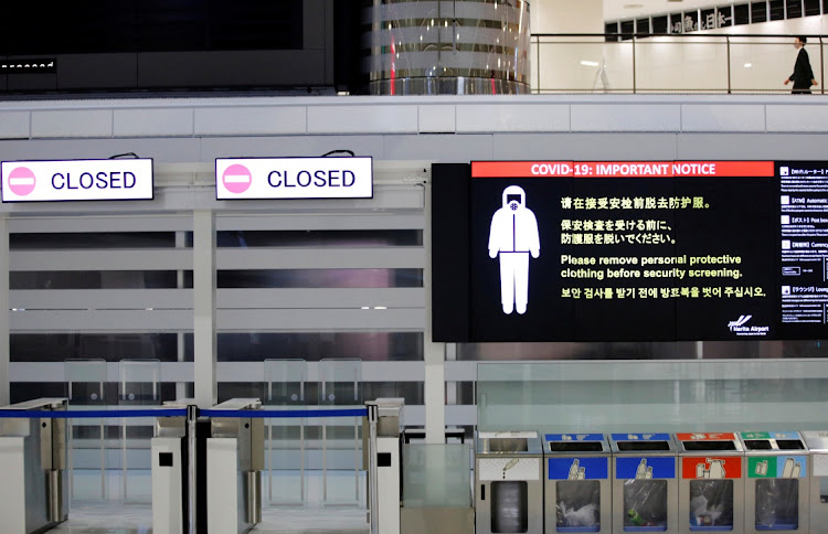 A notice about Covid-19 safety measures is pictured next to closed doors at a departure hall of Narita international airport in Narita, east of Tokyo, Japan, on November 30 2021. File Photo.