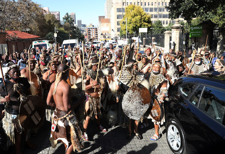 Amabutho stand outside the buildings to witness as Queen Mantfombi's body leaves for KZN.