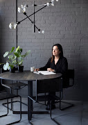 Homeowner Kim Smith (pictured) used a striking pendant light to define the dining area within the open-plan living area.