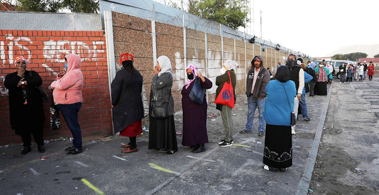 Patients ignore physical-distancing lines on the pavement outside Hanover Park clinic in Cape Town.