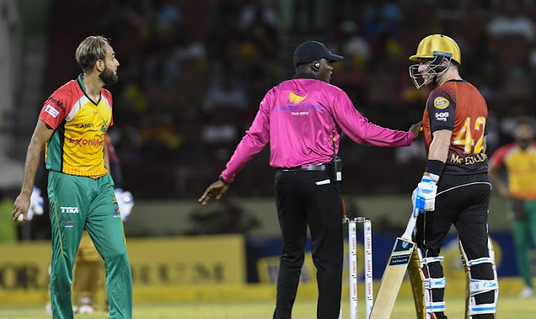 In this handout image provided by CPL T20, Umpire Langton Rusere (C) tries to calm Brendon McCullum (R) of Trinbago Knight Riders and Imran Tahir (L) of Guyana Amazon Warriors during match 30 of the Hero Caribbean Premier League between Guyana Amazon Warriors and Trinbago Knight Riders at Guyana National Stadium on September 9, 2018 in Providence, Guyana.