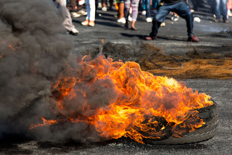 Police are searching for community members believed to be behind the murder of a young man who was beaten and torched.