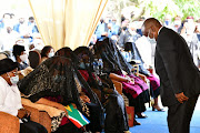 President Cyril Ramaphosa pays his respects to the grieving widows of King Goodwill Zwelithini during a memorial service on Thursday.