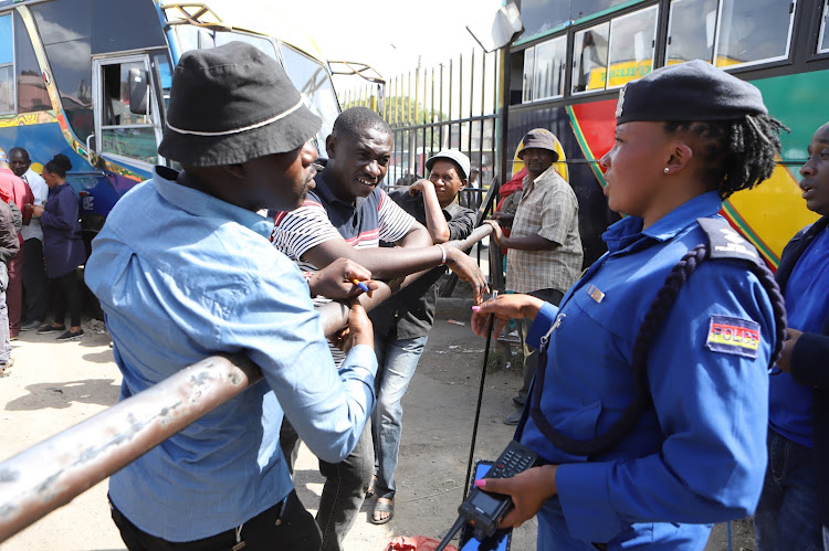 Muoroto Police Base officer in-charge Faith Njoroge engages bus operators during intensified patrols ahead of Christmas festivities at Machakos Country Bus, Nairobi on December 22