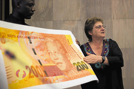 Reserve Bank governor Gill Marcus holds up a replica of the new R200 bank note, depicting former president Nelson Mandela, at the bank's headquarters in Pretoria. File photo.