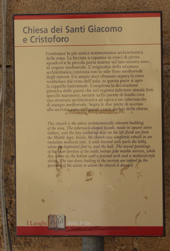 Plaque reads: 'This church is the oldest architectonically  relevant building of the area. The tabernacle shaped facade, made in square stone ashlars, and the tiny walled-up door on the left flank...