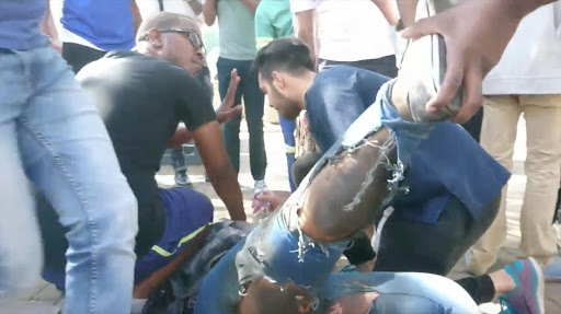 A student lies on the ground after reportedly being injured by a stun grenade.