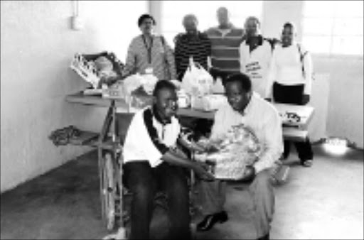 KINDNESS: Bongani Malevu, in the wheelchair, received Christmas goodies from City Power staff. From left are Zelpha Mossion, Thandazani Shange, Tebogo Sehlako, Mlungisi Zulu, Mothusi Moloko and Sol Masolo. 27/12/2008. Pic. Peter Mogaki. © Sowetan.