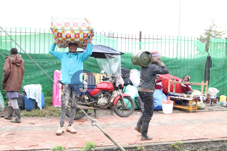 Residents carry their belongings as evacuation of people living on riparian land continued at Kaverera South B on May 6, 2024.