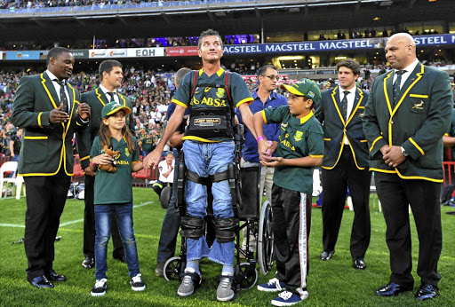 Holding hands with his daughter, Kylie, and son, Jordan, Van der Westhuizen attends a test at Ellis Park in 2014.