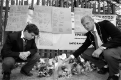 SAD REMINDER: Mark and Hennie Stapelberg lay wreaths at the site where fellow pupil Jacques Pretorius was slain on Monday at the Nic Diederichs Technical School in Krugersdorp. Pic. Mohau Mofokeng. 19/08/08. © Sowetan.