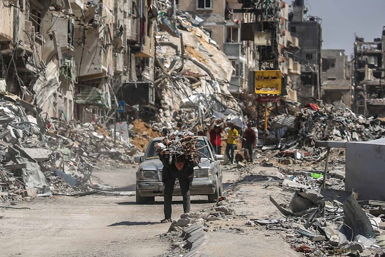 A man carries items on his back in Khan Yunis, Gaza, April 13 2024. Picture: Ahmad Hasaballah/Getty Images