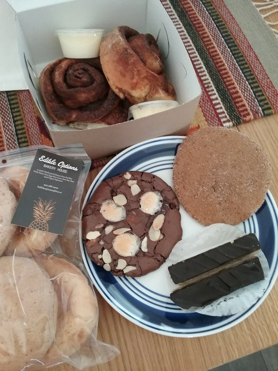 Cinnamon buns with icing on the side, rocky road cookie, ginger molasses cookie, twix bars, hamburger rolls