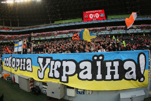 FC Shakhtar fans cheer behind a banner reading "United Ukraine" during a Ukrainian Premier league game against FC Dnipro in Donetsk on March 22, 2014. Three clubs in Crimea, annexed by Russia in March, were given the all clear to join the Russian third division by the Russian football federation (RFU), sparking a forceful response from Anatoly Popov, deputy president of the Ukraine Football Federation (FFU). File photo