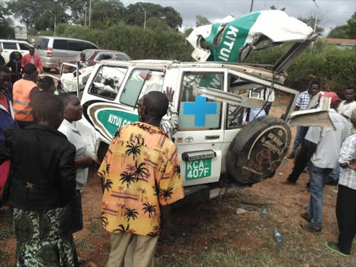 Curious residents surround the wreckage of Kitui County ambulance at Mwingi police station. The vehicle was involved in an accident that left two people dead. Photo/ Lydia Ngoolo