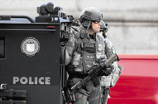 SWAT officers patrol the Copley Square area near the finish line of the Boston Marathon. Three people, including a boy aged eight, were killed when two bombs ripped through the crowd on Monday