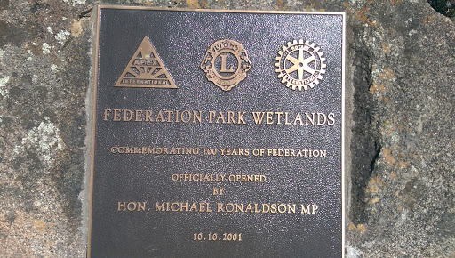 Plaque on the outskirts of Stawell at the start of a short boardwalk.  Has the Apex club, Lions club and Rotary club logos on the top. Plaque reads: Federation Parks Wetlands Commemorating 100...