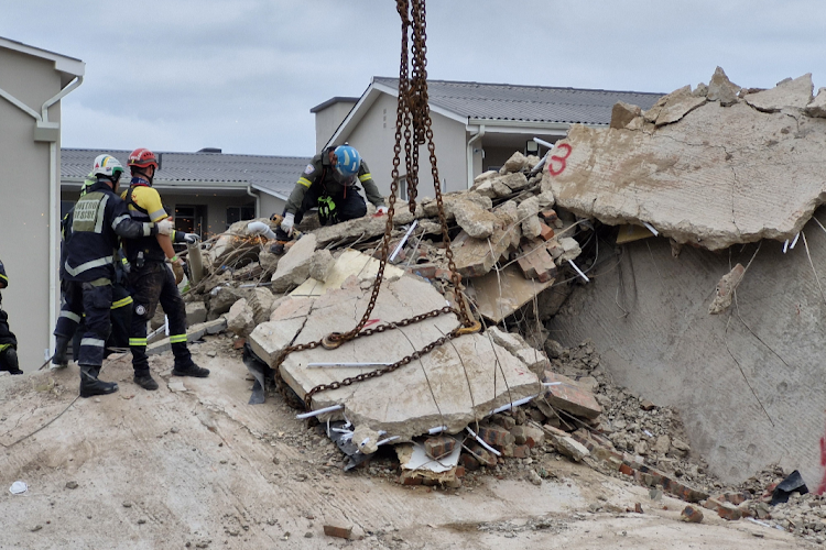 About 200 emergency services personnel are working around the clock to rescue workers trapped under rubble at the construction site in George