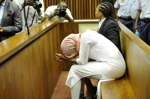 Sindisiwe Manqele covers her head with a scarf as she appears in the Randburg Magistrate's Court on December 9, 2015 in Johannesburg, South Africa. Manqele was found guilty of murdering her boyfriend, Nkululeko "Flabba" Habedi in March this year, an act which she claims was self-defence.