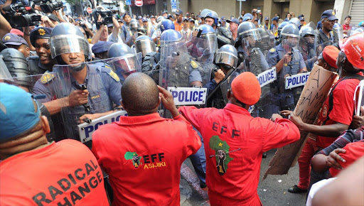 Protesting supporters of the opposition Economic Freedom Fighters (EFF) clash with police ahead of the opening of parliament ceremony in Cape Town.