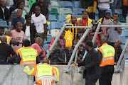 Officials try to stem crowd violence during the first half of the Nedbank Cup semifinal match between Kaizer Chiefs and Free State Stars at Moses Mabhida Stadium in Durban on Saturday.